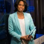 Confident woman in a server room, holding a tablet. Ideal for tech and business themes.